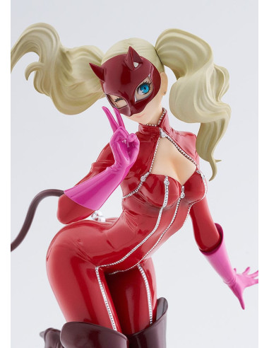 Gros plan sur le visage de la statuette, elle adresse un clin d'oeil et fait le signe V avec ses doigts