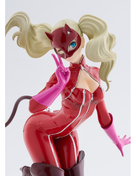 Gros plan sur le visage de la statuette, elle adresse un clin d'oeil et fait le signe V avec ses doigts