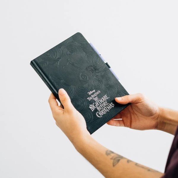 Carnet premium A5 Disney L'Étrange Noël de Mr Jack tenu en main avec couverture texturée.
