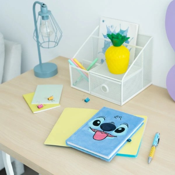 Carnet premium A5 en peluche Disney Stitch Tropical présenté sur un bureau avec son stylo projecteur.