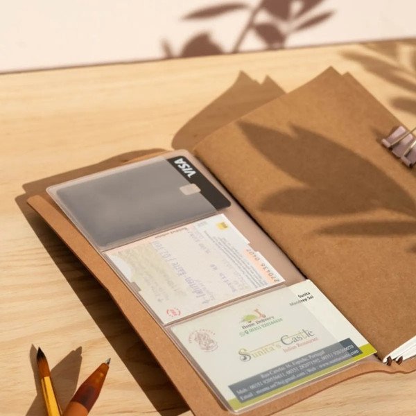 Intérieur du carnet de voyage Jurassic Park avec pochettes transparentes pour ranger tickets et souvenirs.