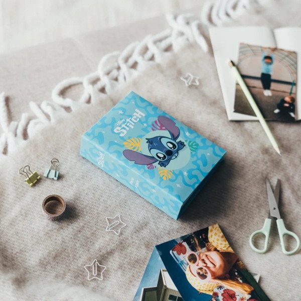 Album photo Disney Stitch 100 pochettes 10x15 cm pose sur un plaid avec couverture visible