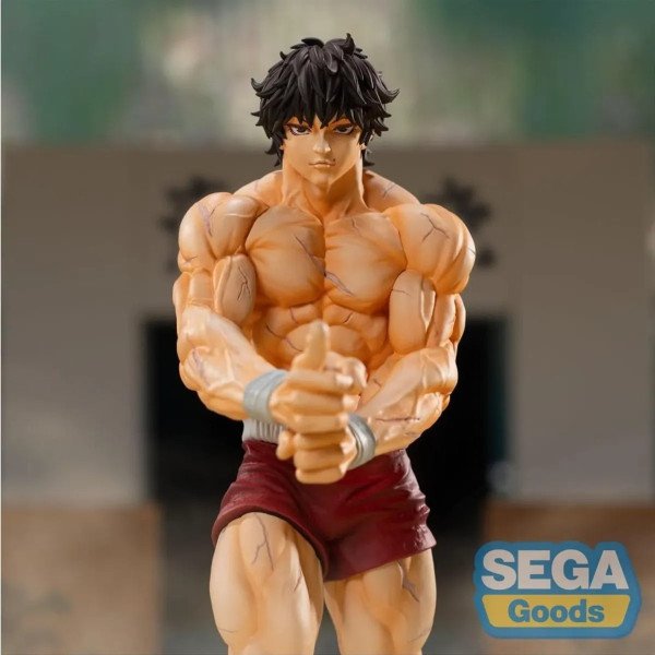Gros plan sur Baki Hanma Luminasta SEGA, torse musclé, mains jointes et regard concentré.
