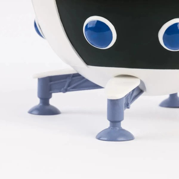 Détail des pieds bleus du pot à crayons Dragon Ball Z Capsule Corp en forme de vaisseau.